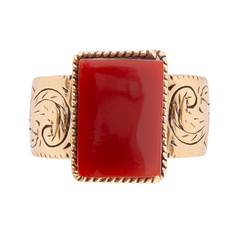 Gold bracelet with a red stone on a white background