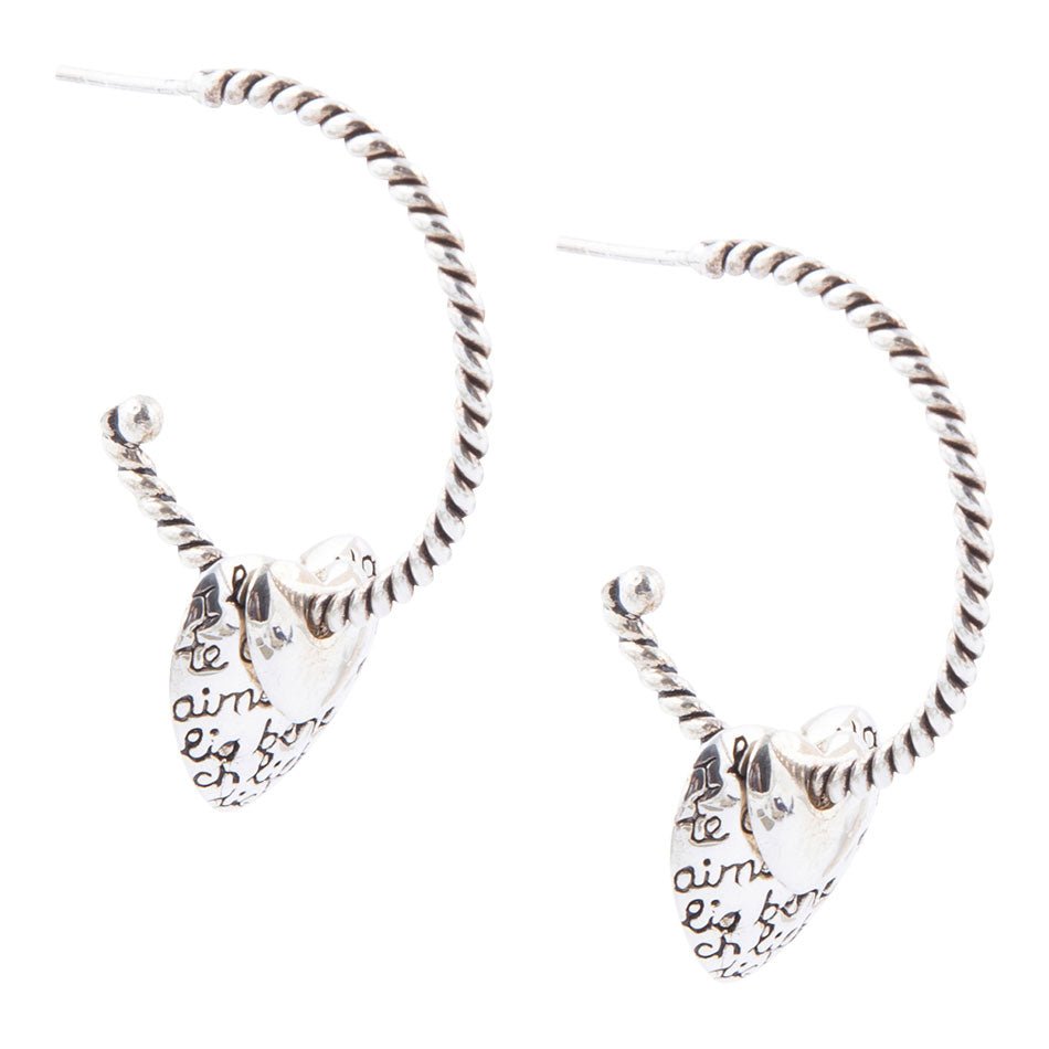 Silver hoop earrings with heart-shaped charms on a white background