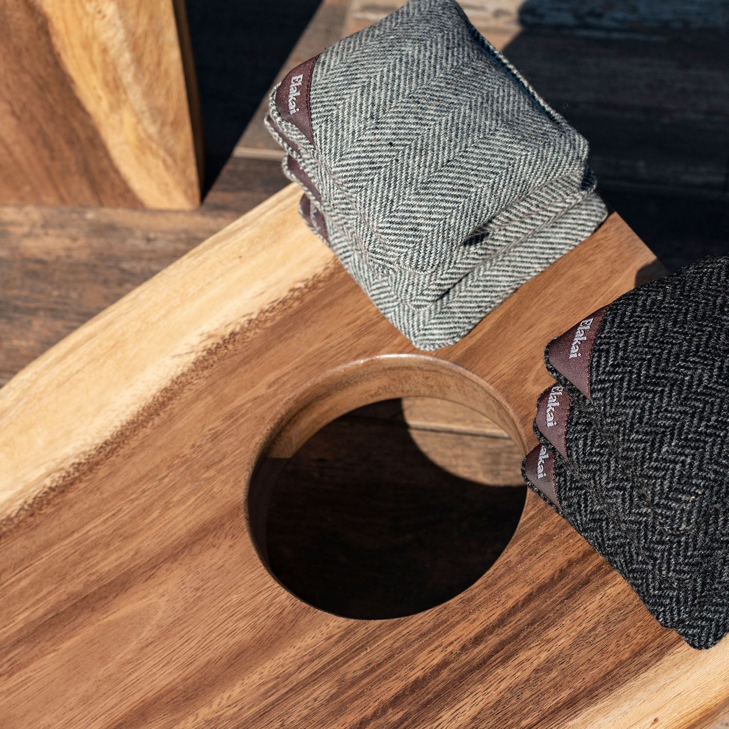 Gray herringbone fabric with a brand label on a wooden surface