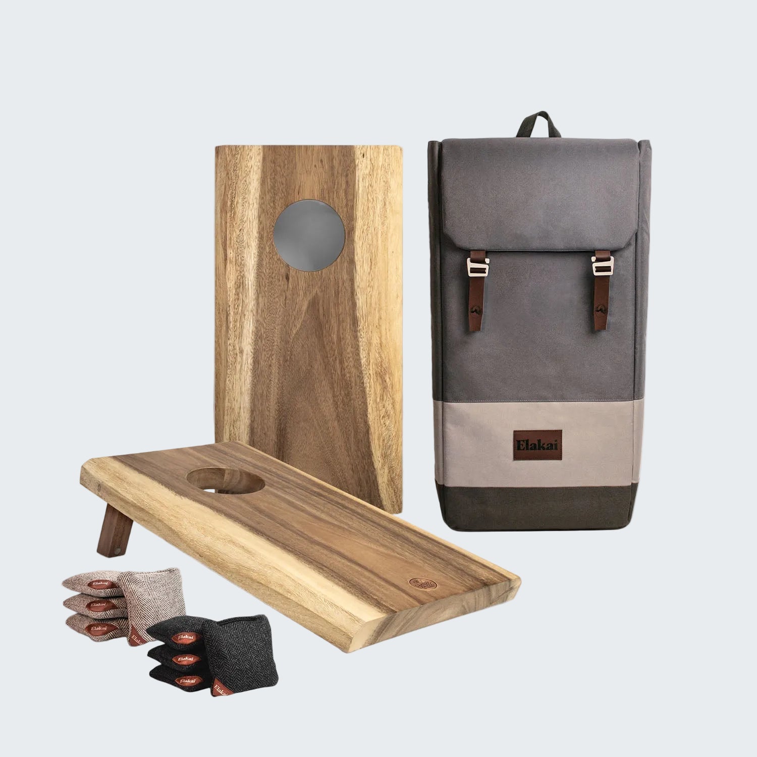 Wooden cornhole boards with bags and a gray backpack on a white background