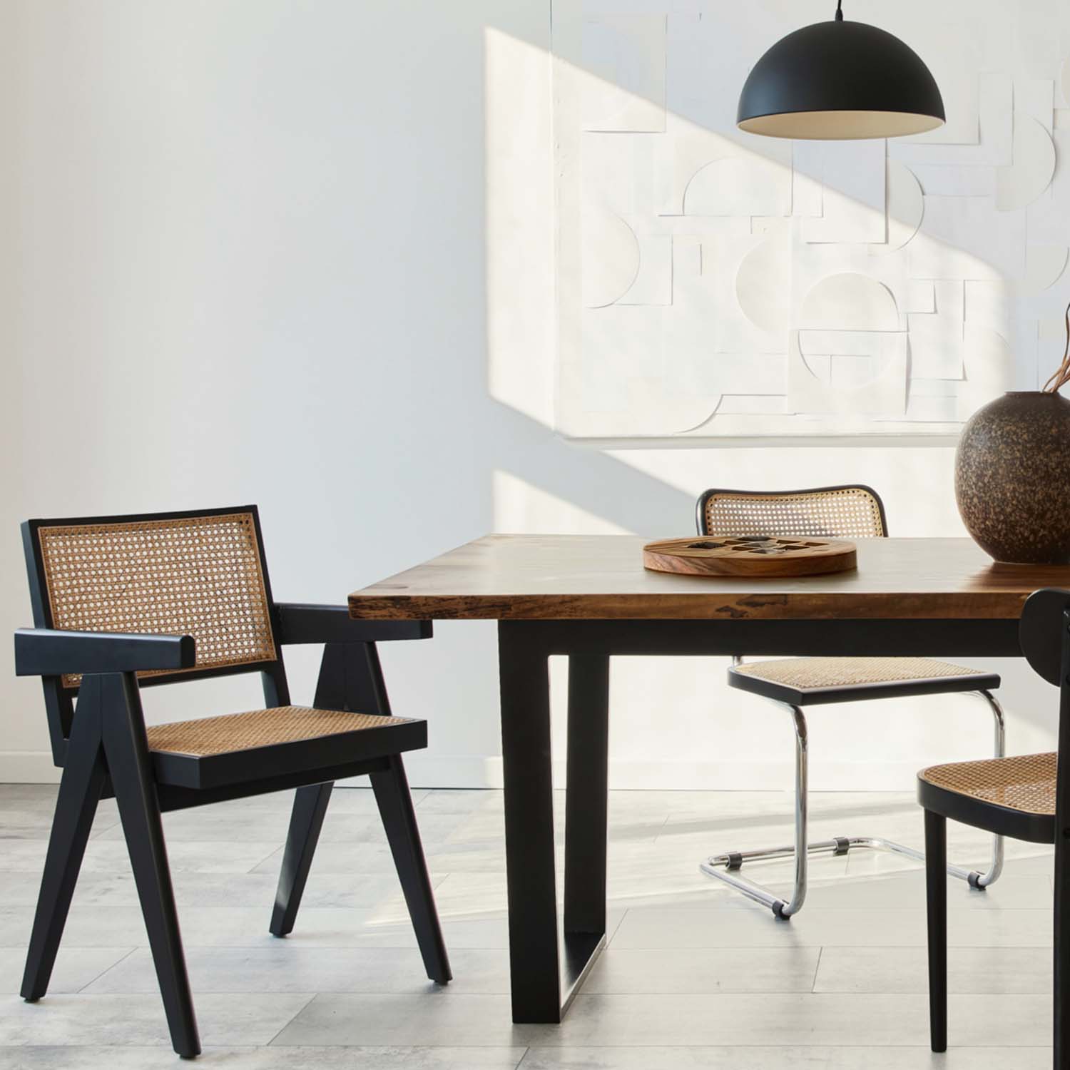 Dining area with wooden table and black chairs in a modern interior.
