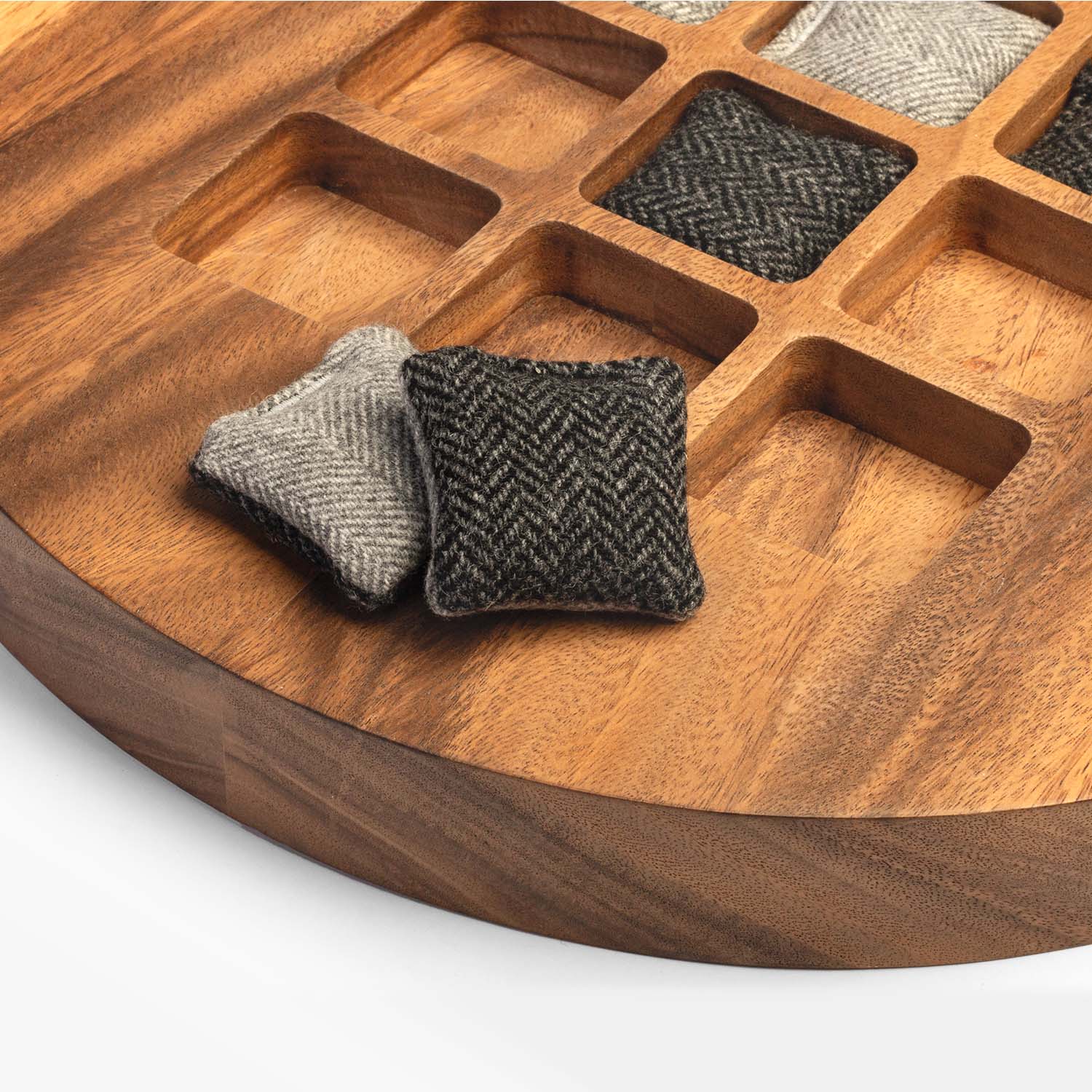 Wooden tray with woven fabric squares on a white background