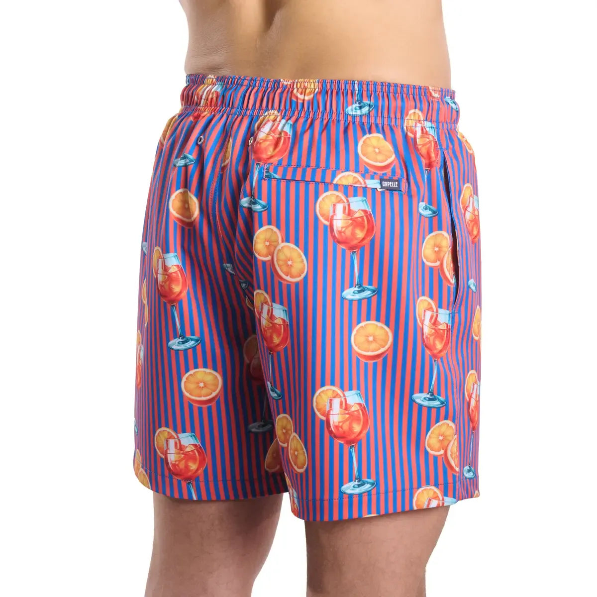Colorful swim shorts with cocktail and orange pattern on a white background