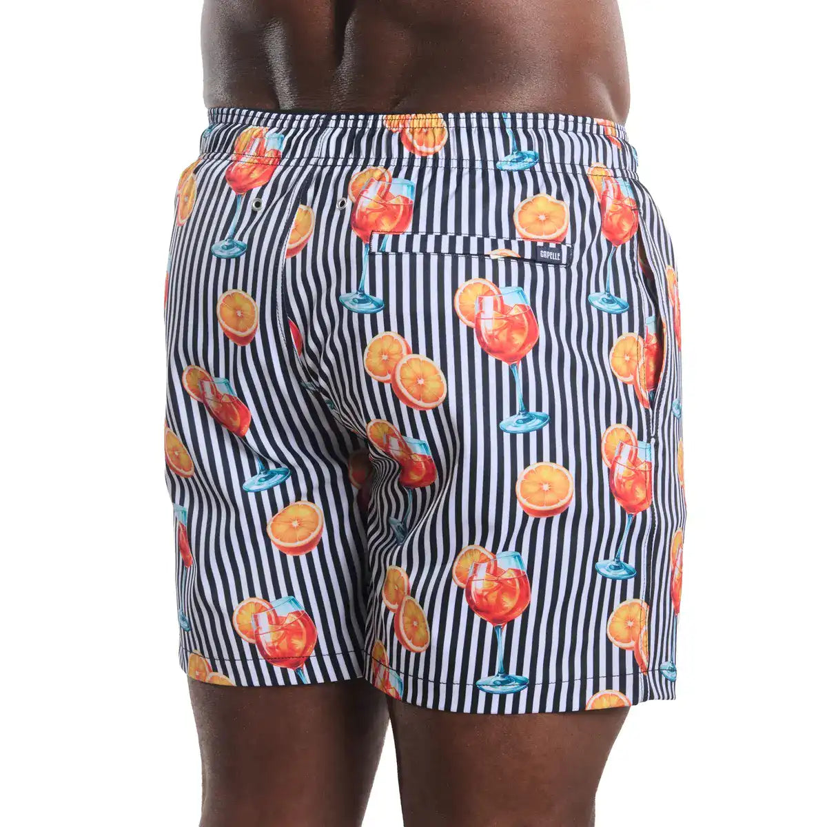 Shorts with a colorful pattern of drinks and oranges on a striped background