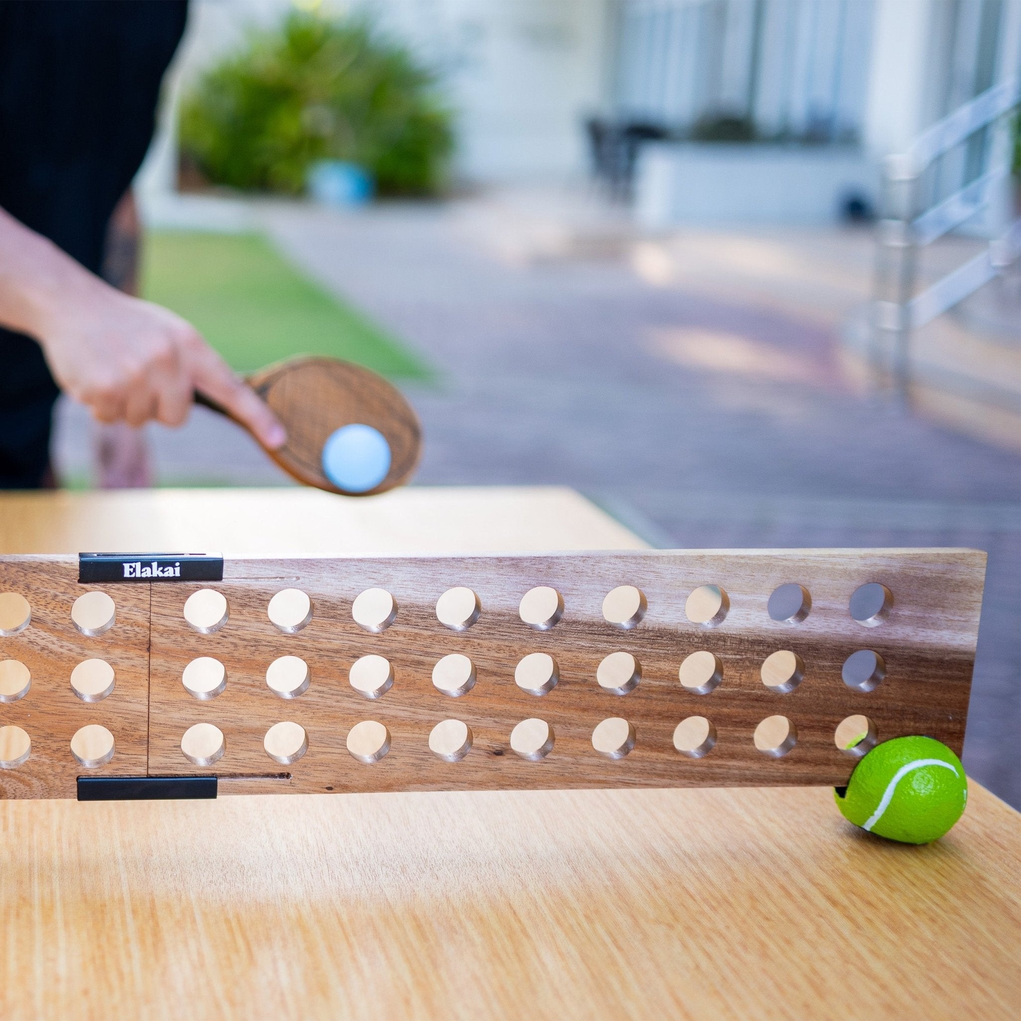 Wooden table tennis set with ping pong ball and paddle on a wooden surface.