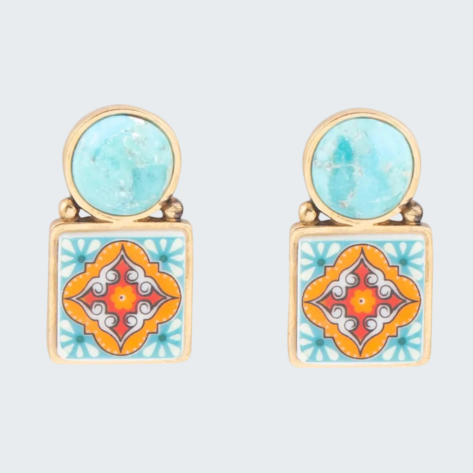 Pair of earrings with turquoise and orange geometric designs on a white background