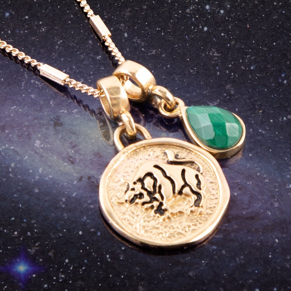 Gold necklace with a pendant featuring an animal design on a dark background