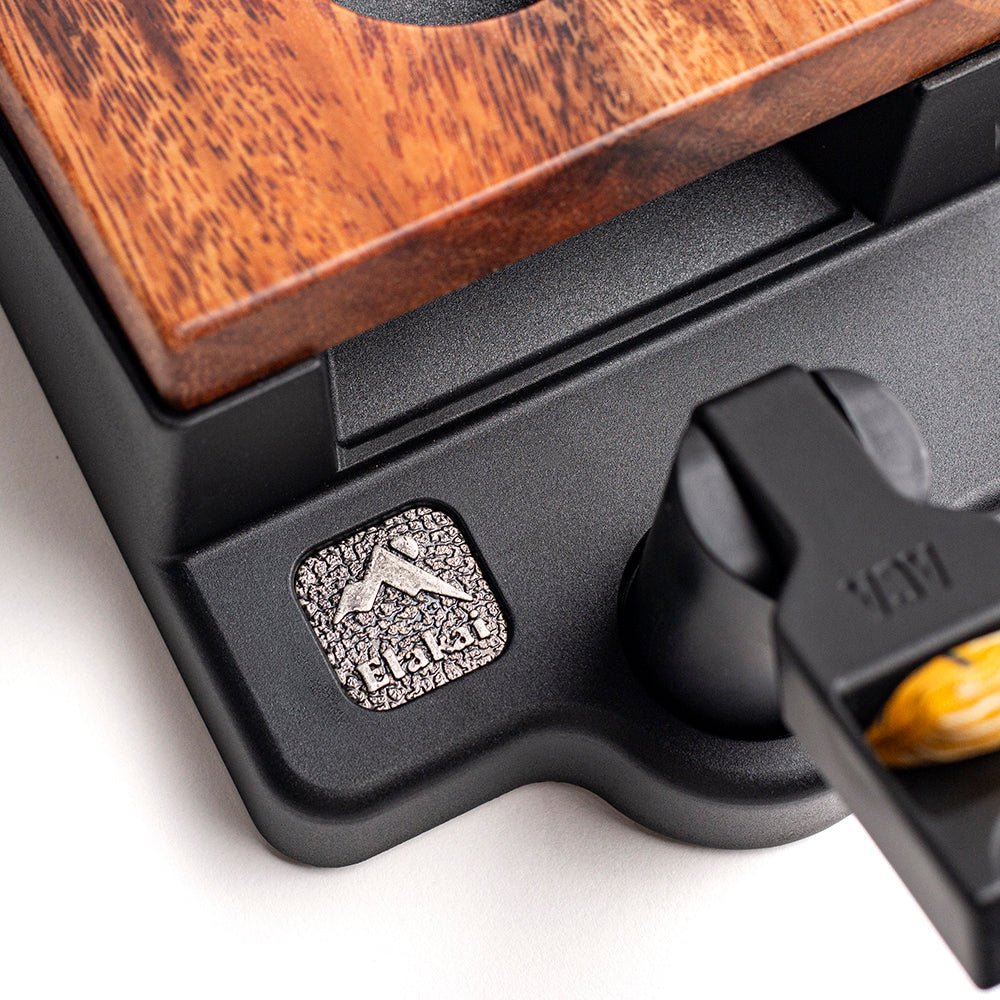 Close-up of a wooden product with a black base and a visible brand logo.