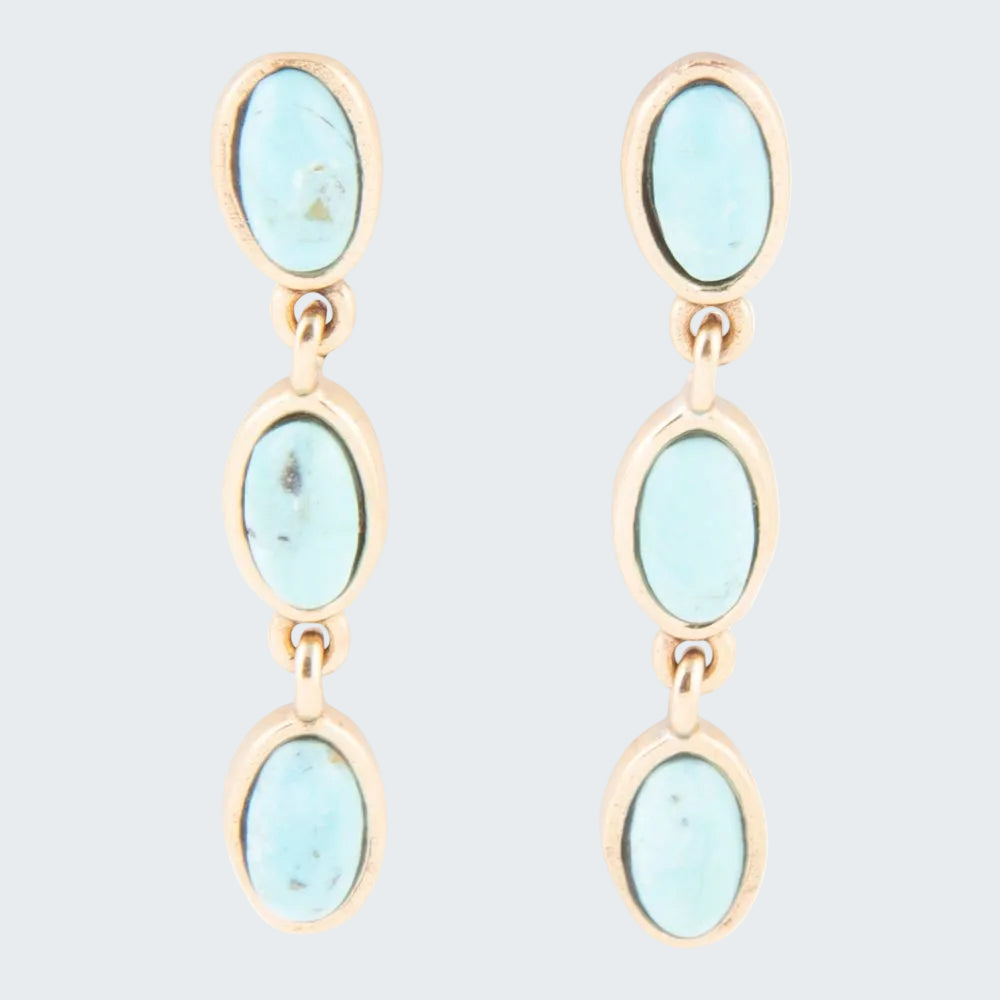 Pair of earrings with light blue stones and gold accents on a white background