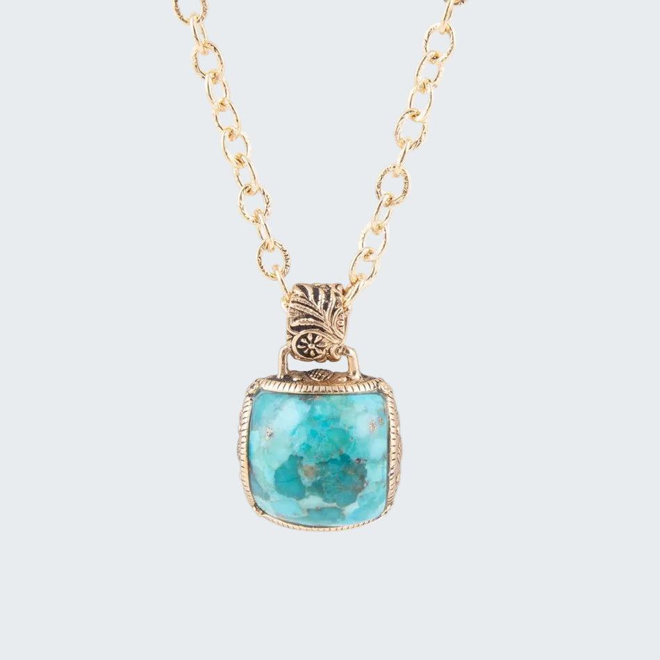 Necklace with a turquoise pendant on a gold chain against a white background