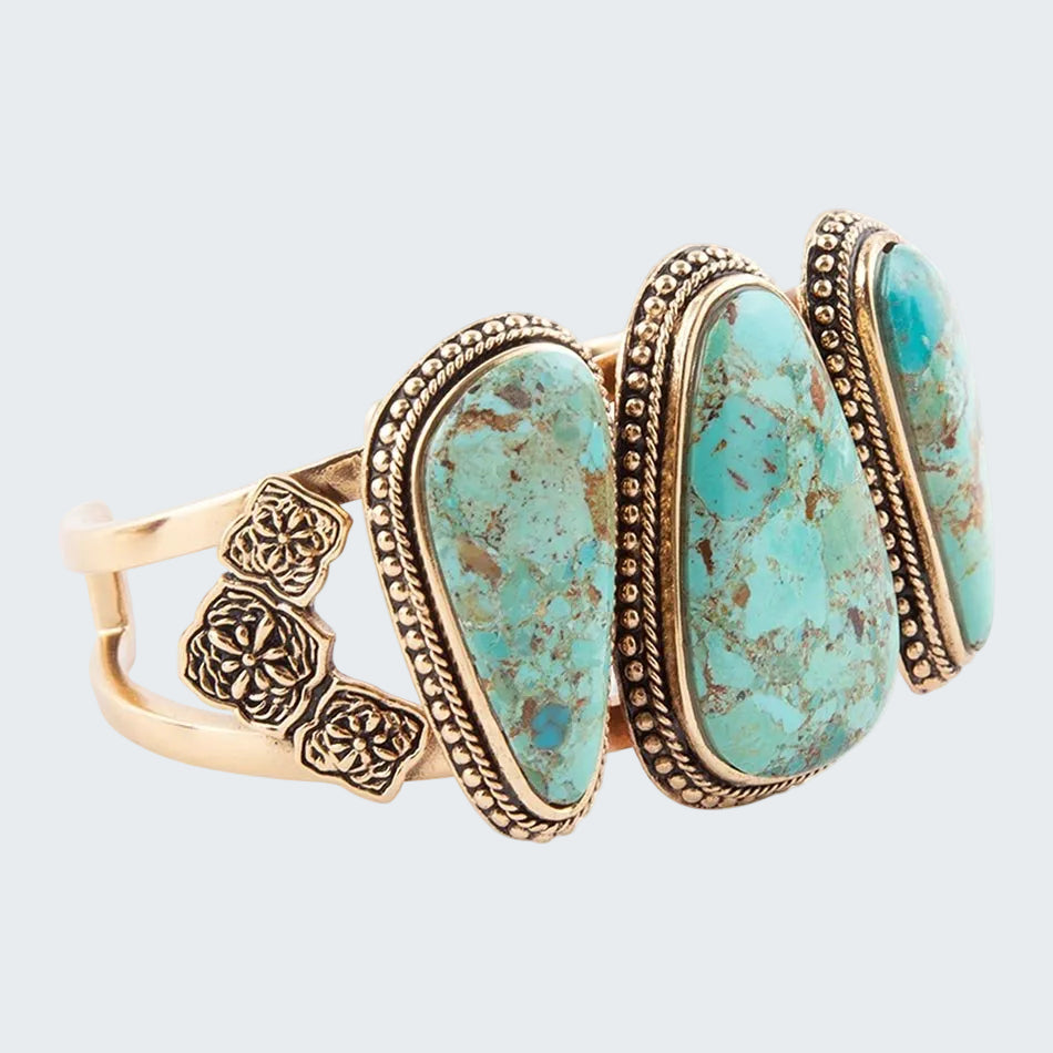 Turquoise stone bracelet with gold accents on a white background