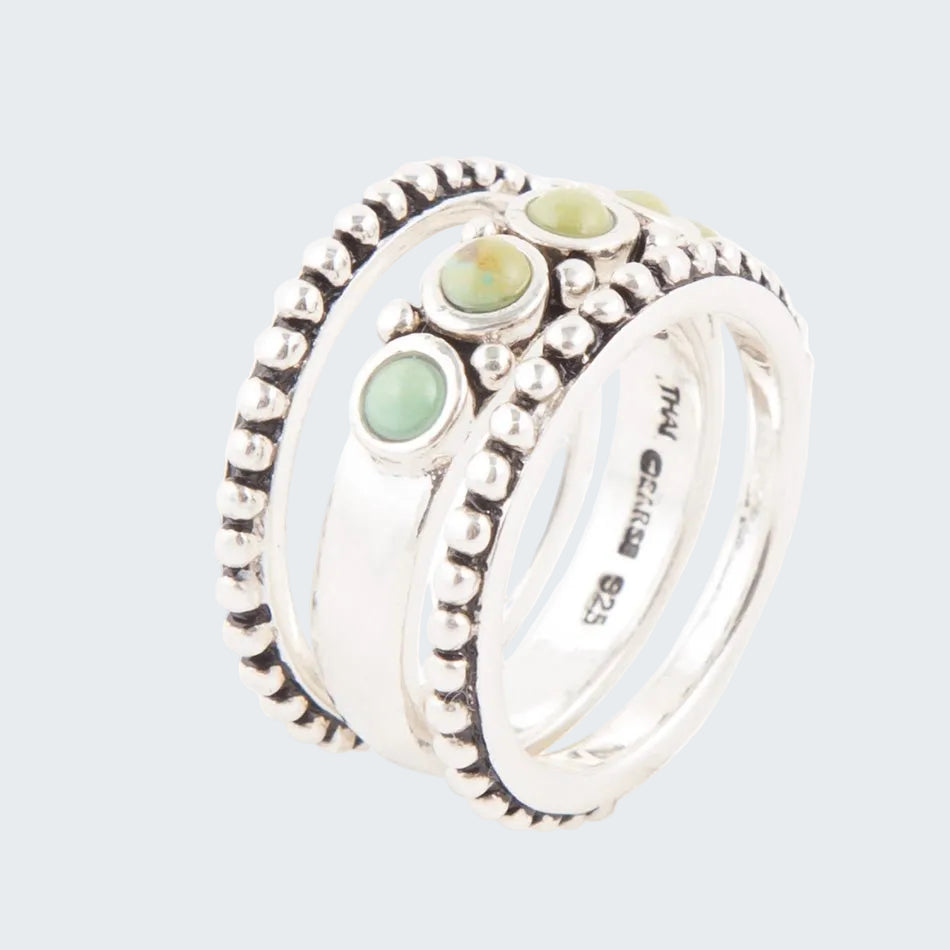Set of silver rings with green gemstones on a white background