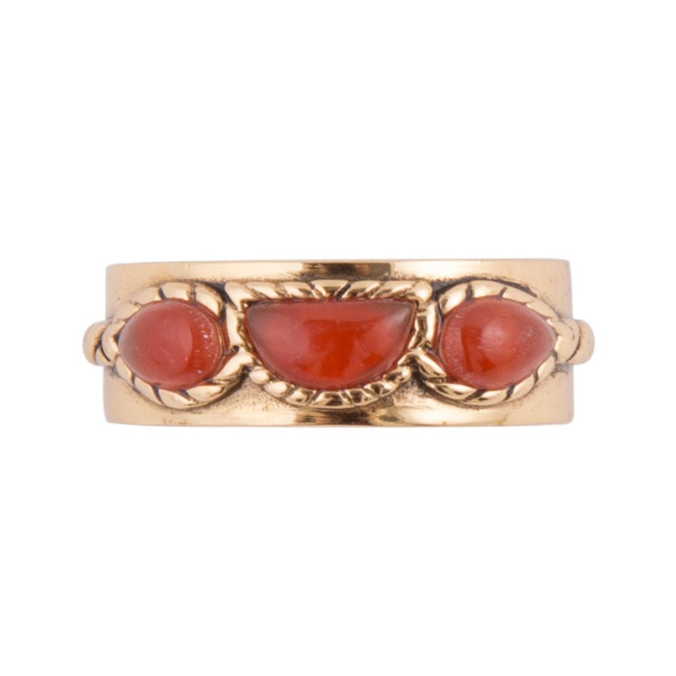 Gold ring with three red stones on a white background