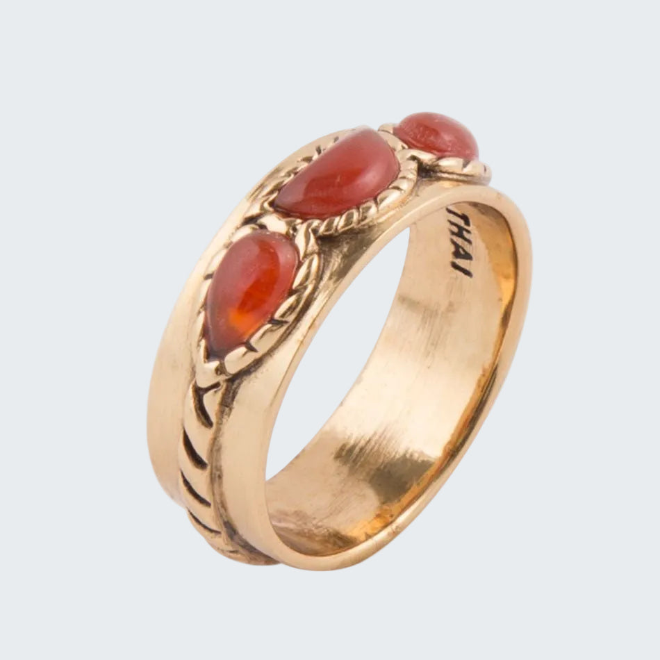 Gold ring with red stones on a white background