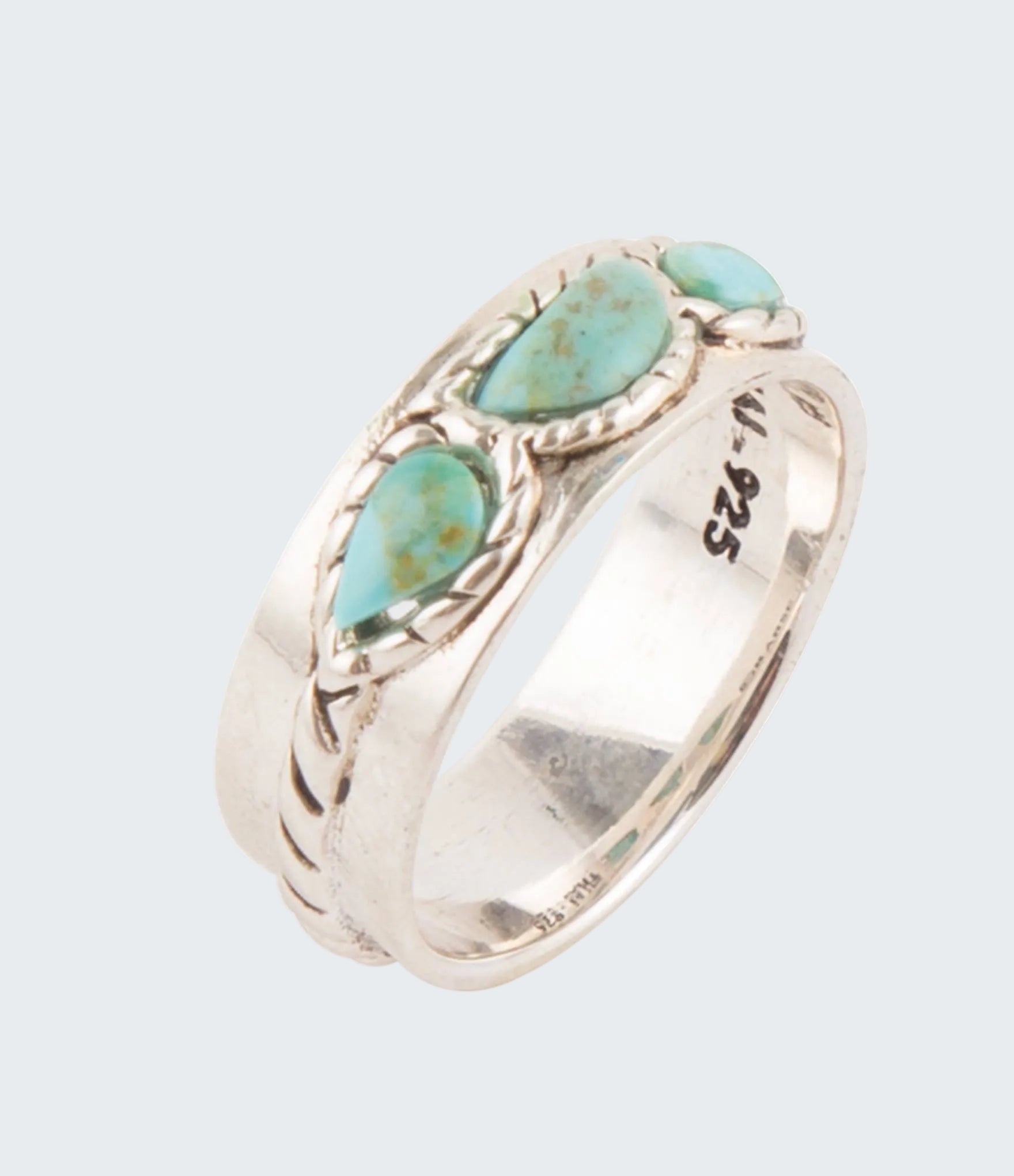 Silver ring with turquoise stones on a white background