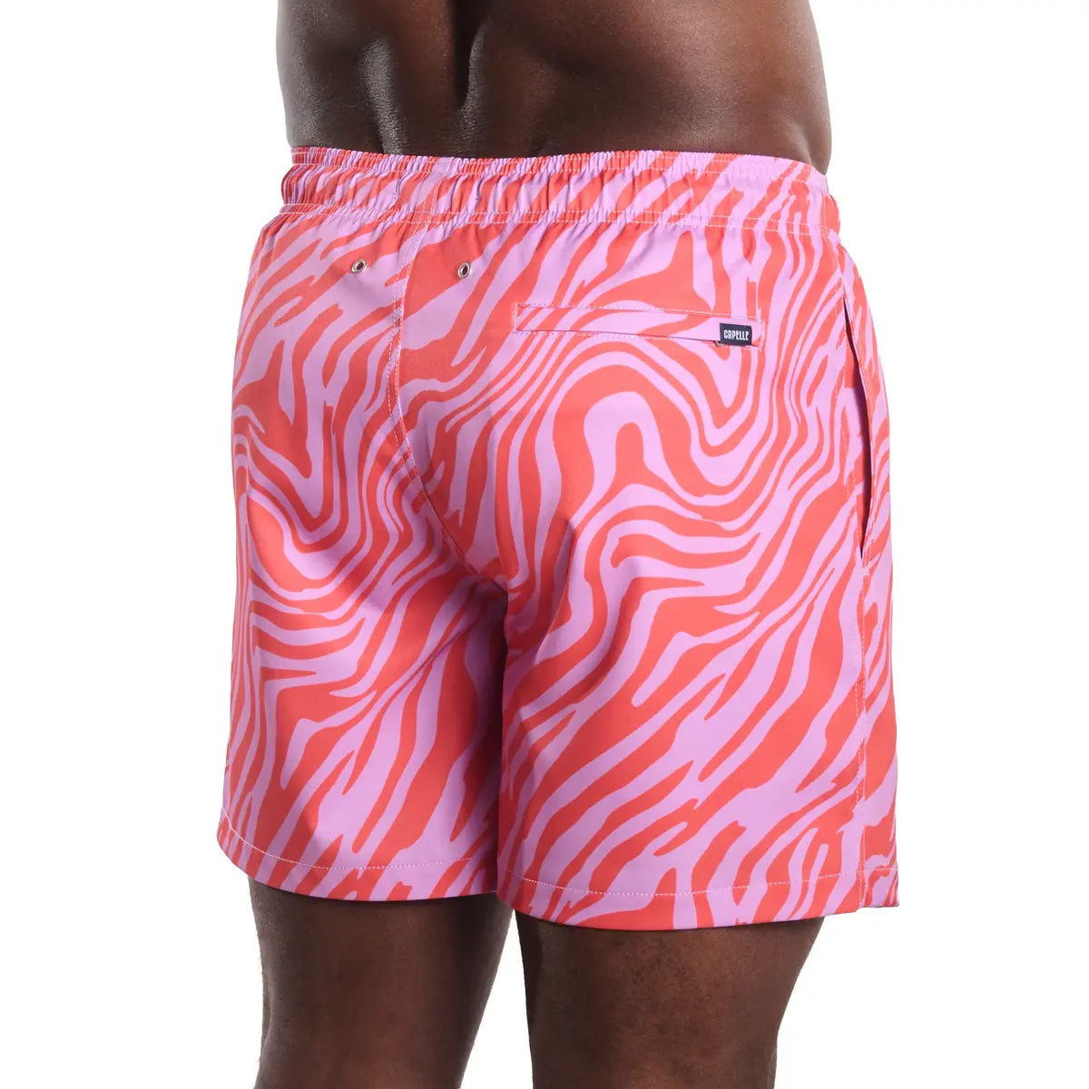 Pink and red zebra patterned swim shorts on a white background