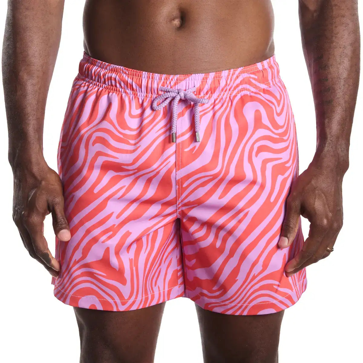 Person wearing pink and red zebra pattern swim shorts on a white background