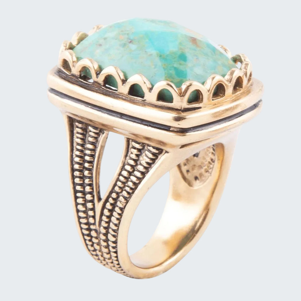 Gold ring with a turquoise stone on a white background