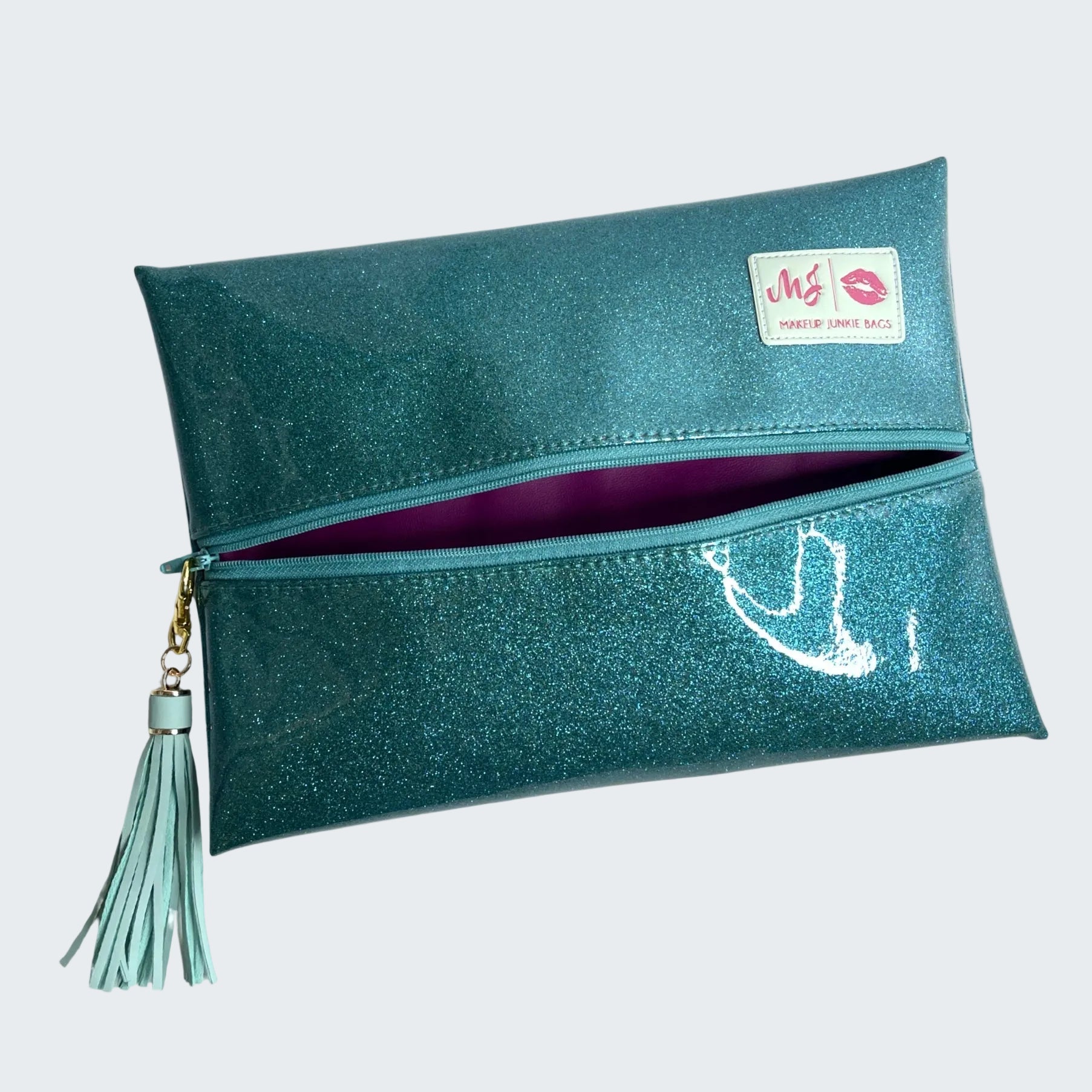 Teal glittery clutch bag with a tassel on a white background