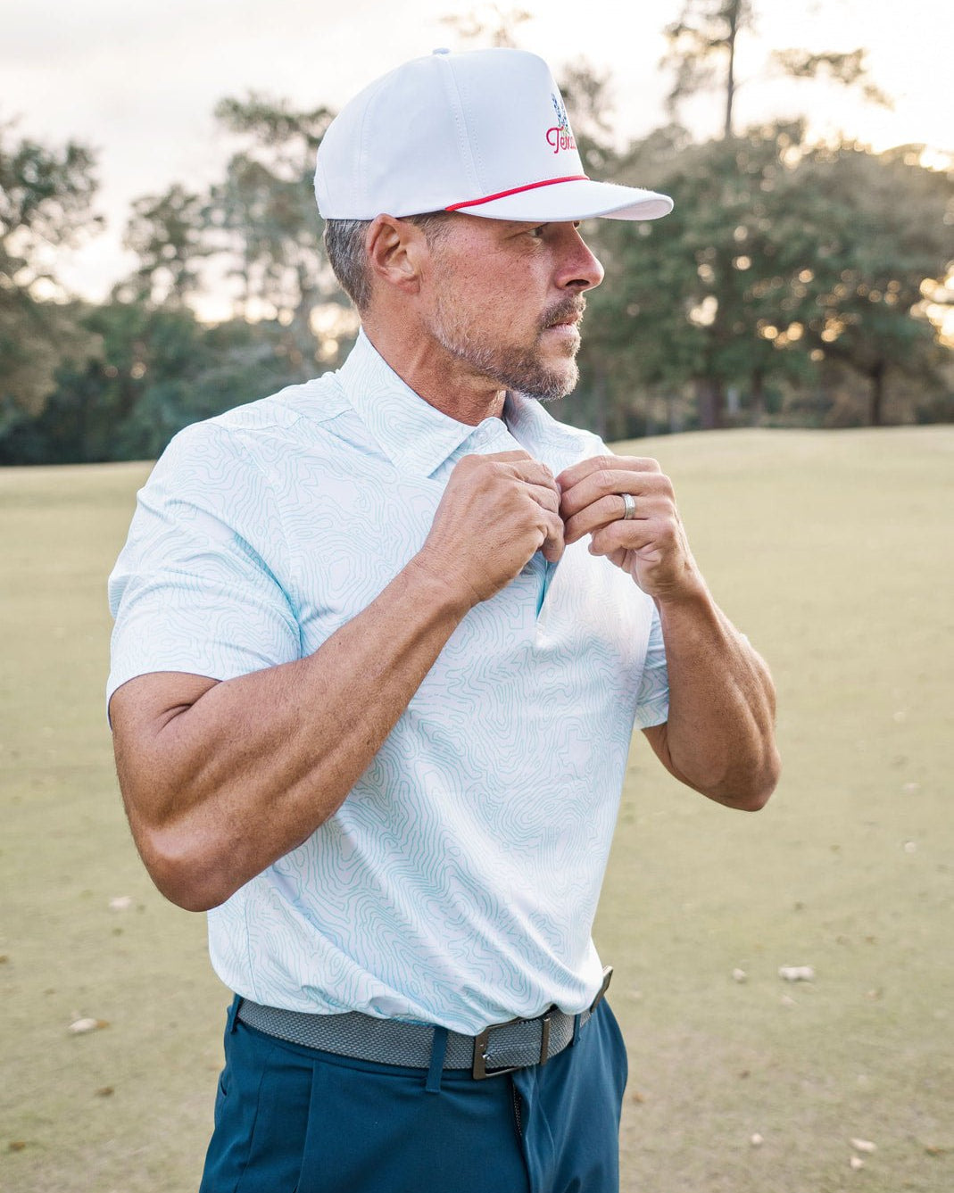 Man adjusting his shirt on a golf course