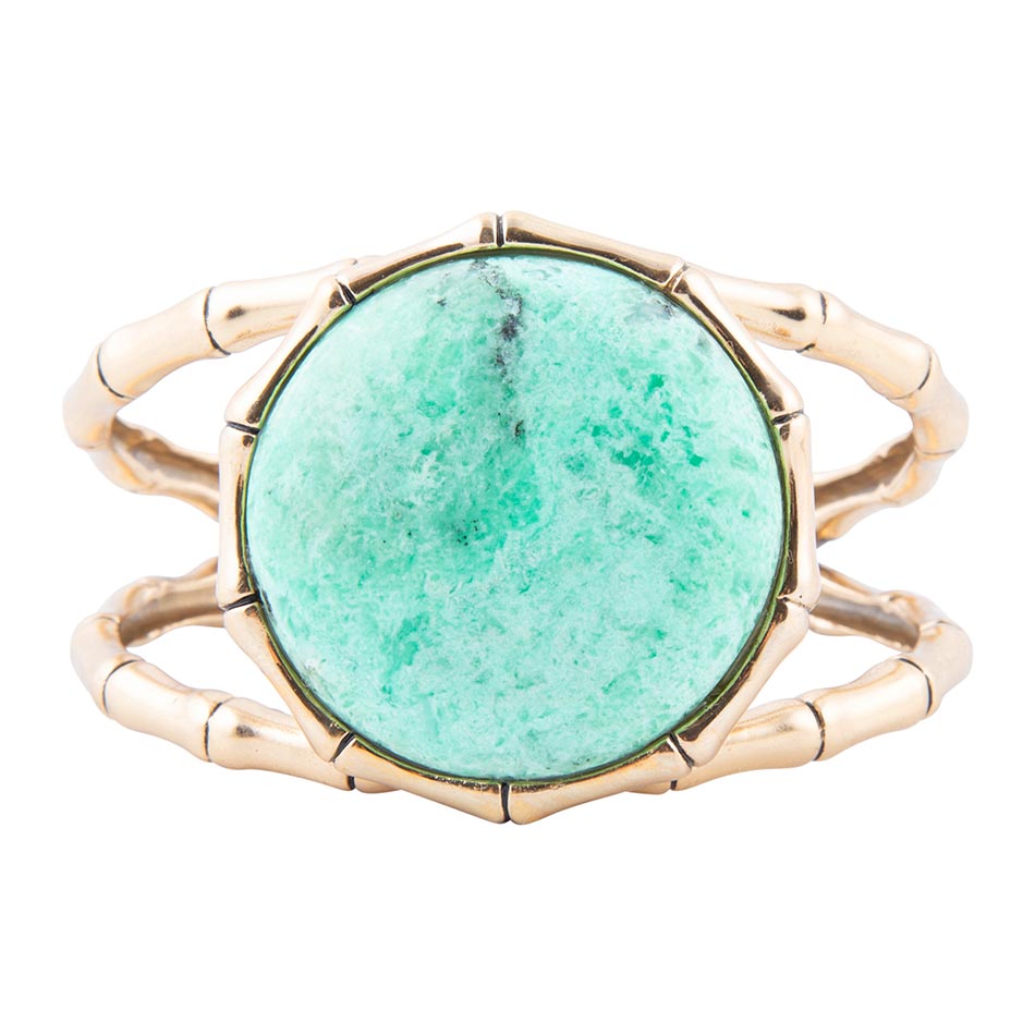Ring with green stone and gold band on a white background