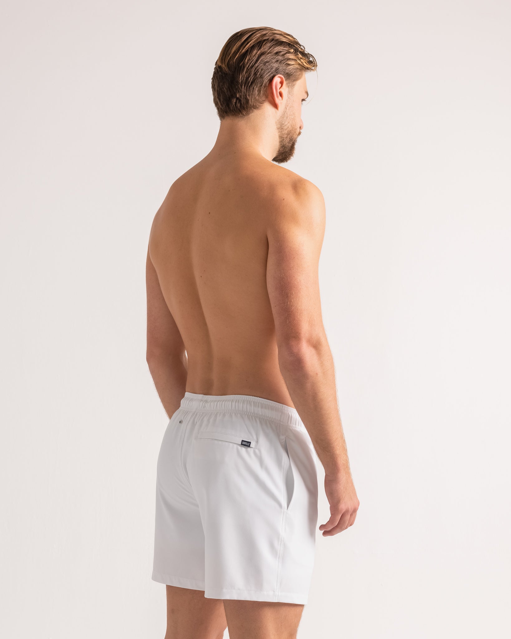 Man wearing white shorts on a plain background