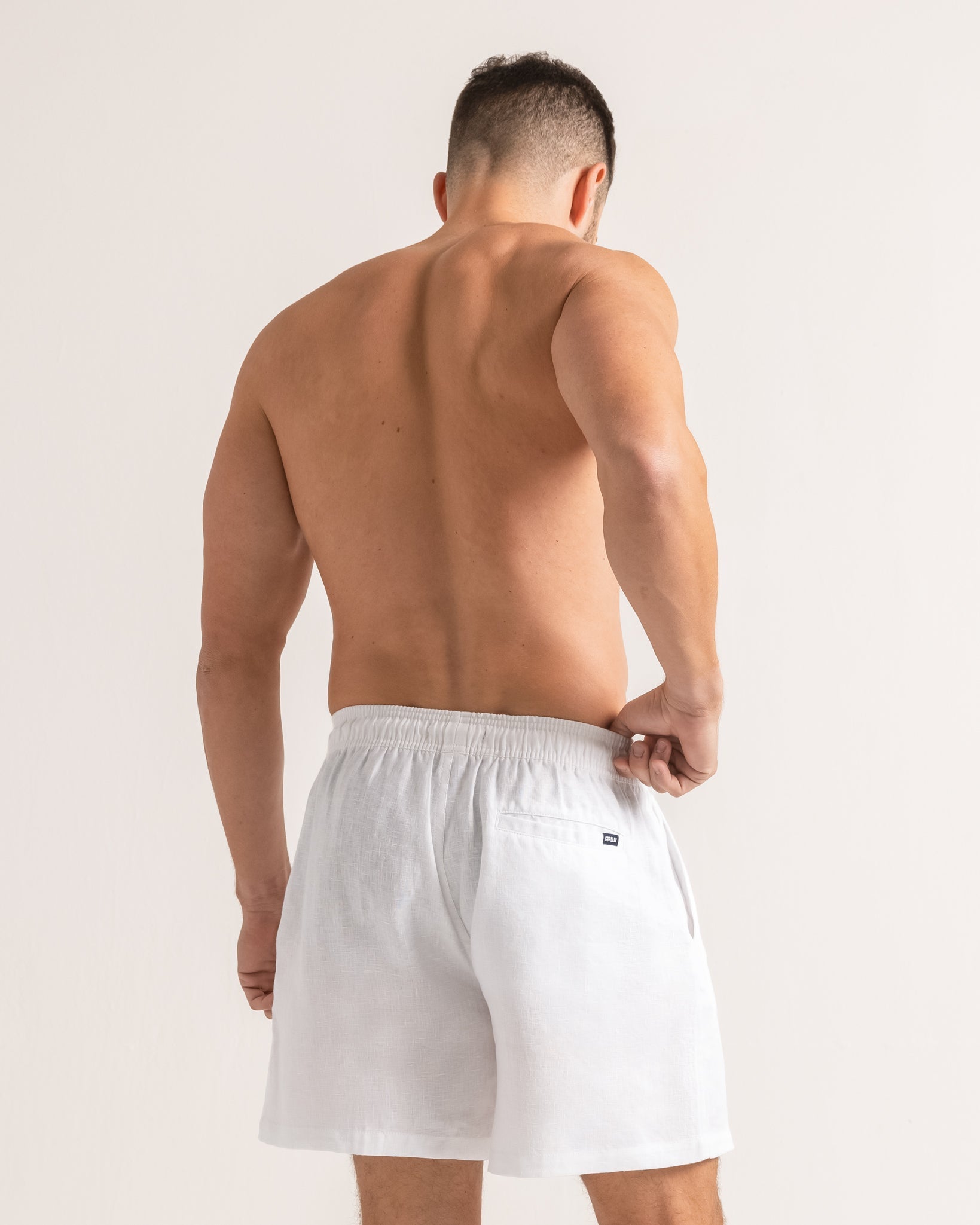 Man wearing white shorts on a plain background