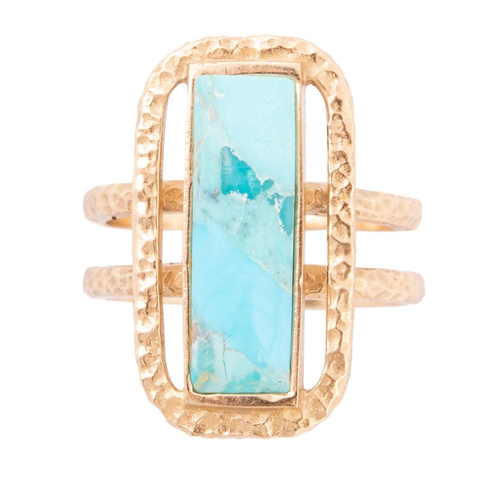Gold ring with a turquoise stone on a white background