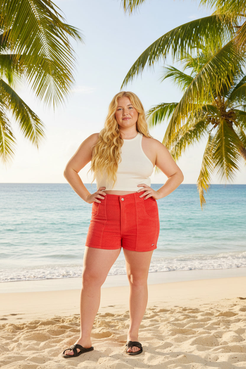 Woman wearing red shorts and a white top on a white background
