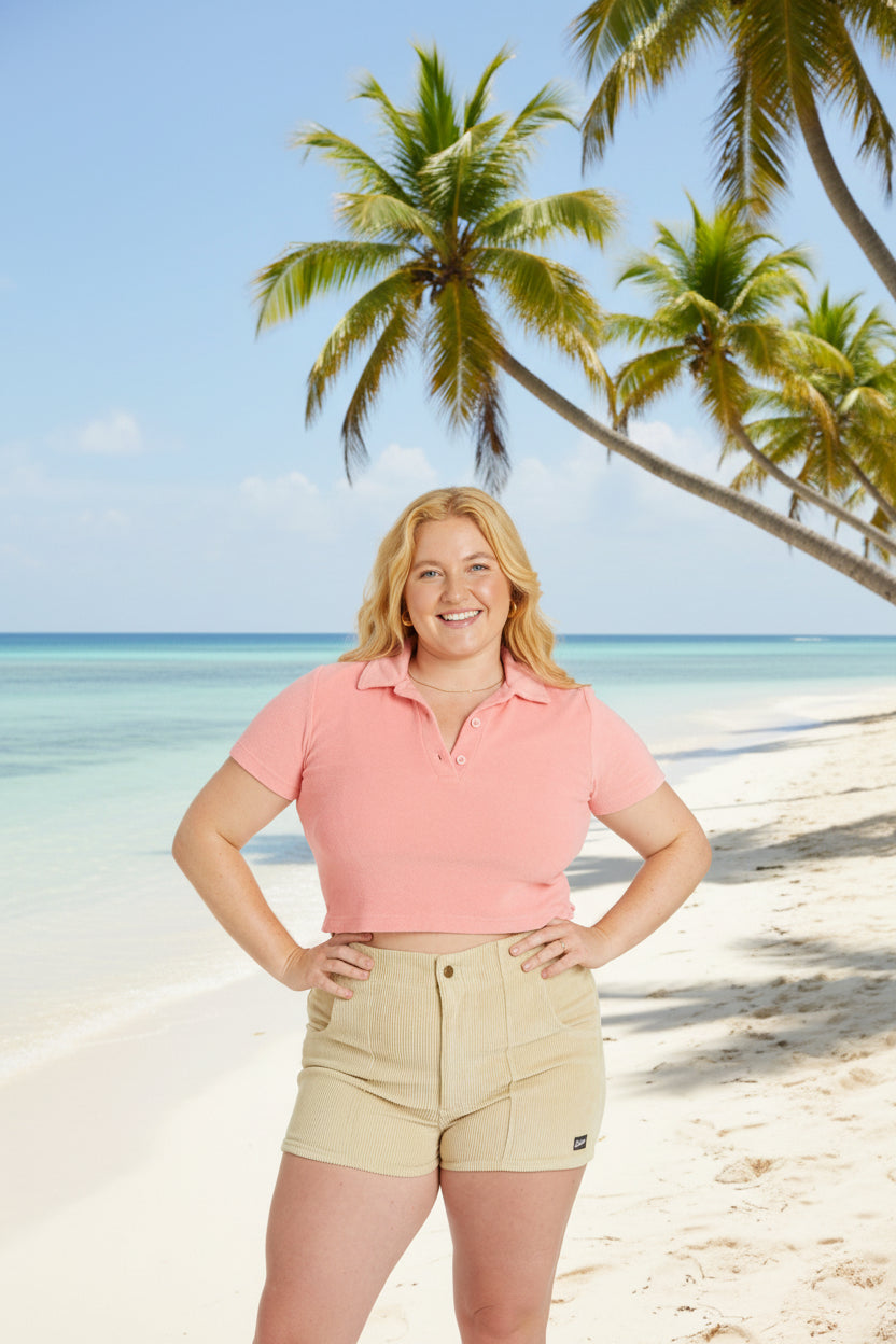 Woman wearing a pink polo shirt and beige shorts on a white background