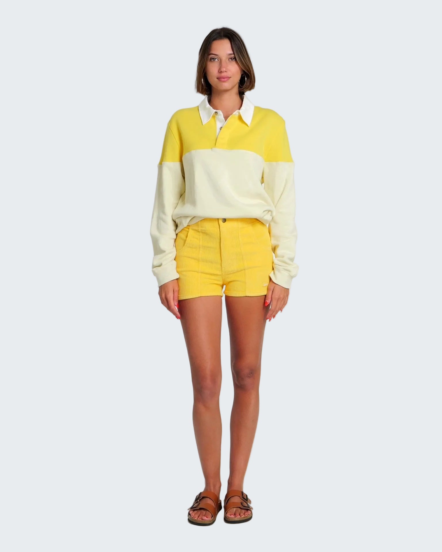 Woman wearing a yellow and white striped sweater with matching shorts on a white background