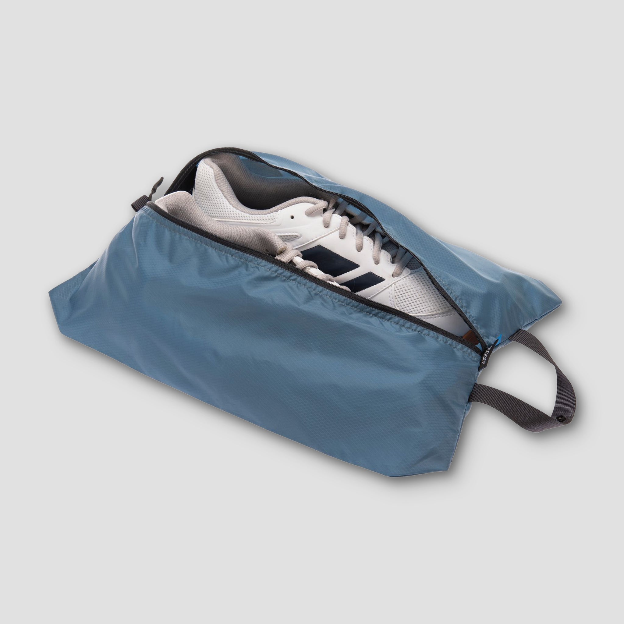 Blue shoe cover with a white sneaker inside on a light gray background