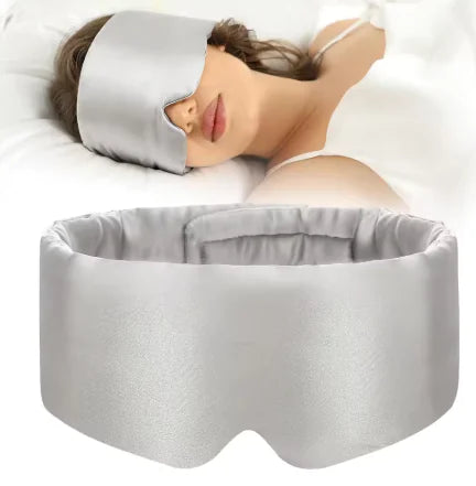 Woman wearing a gray sleep mask with a matching headband on a white background