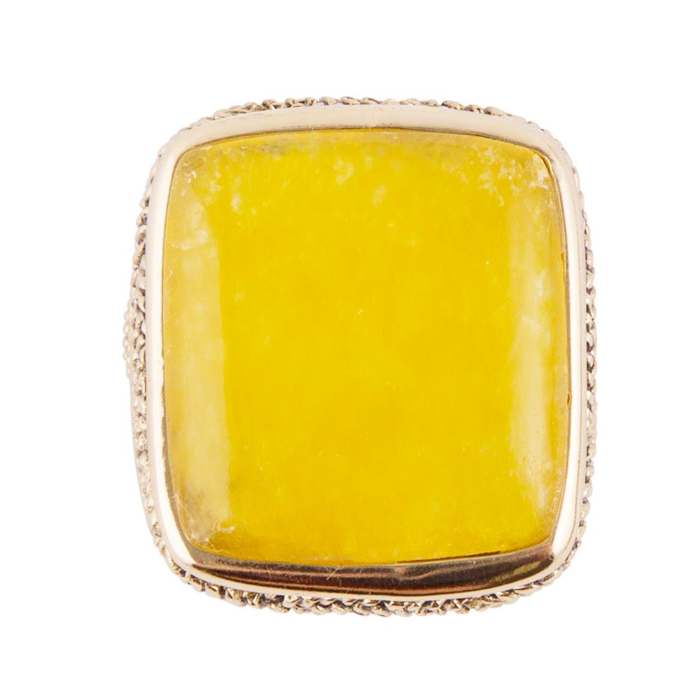 Yellow stone ring with gold band on a white background