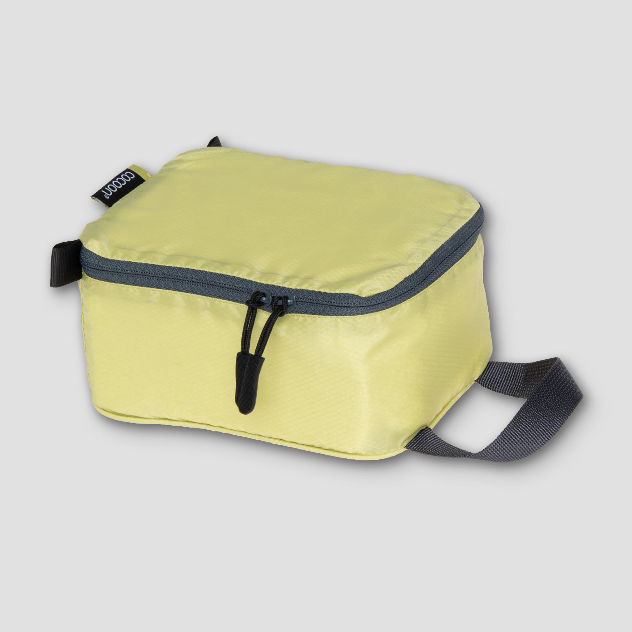 Yellow travel bag with a black zipper and strap on a light gray background