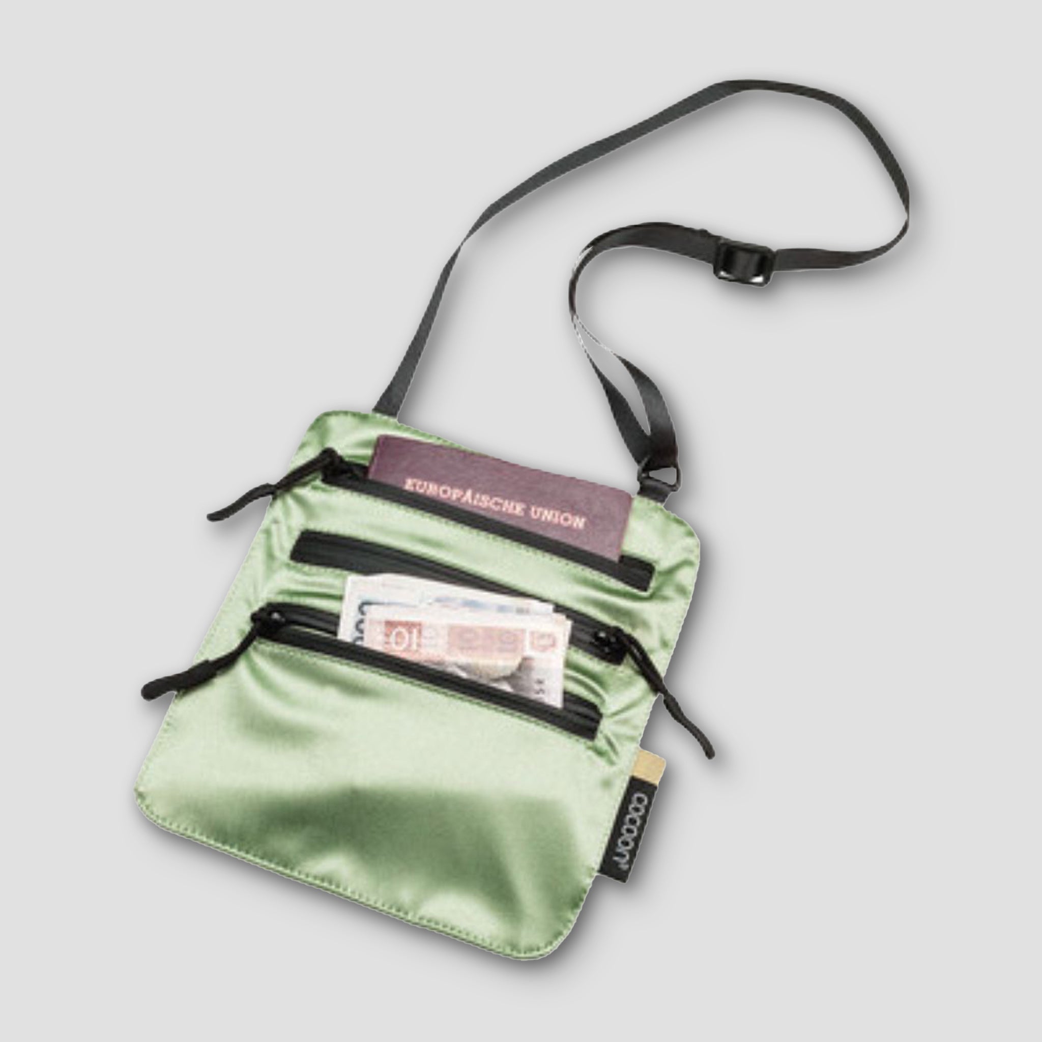 Green crossbody bag with visible brand name on a light gray background