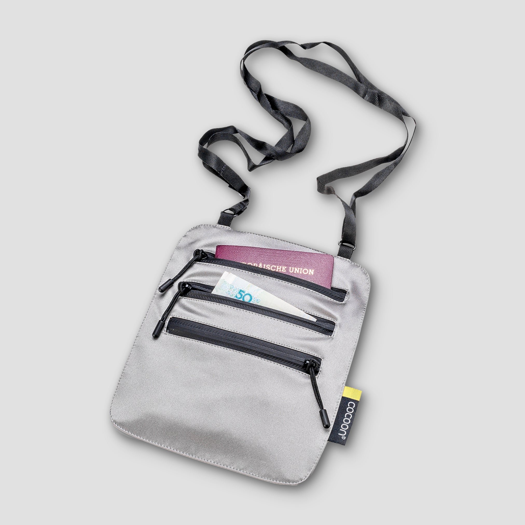 Gray crossbody bag with a strap on a light gray background