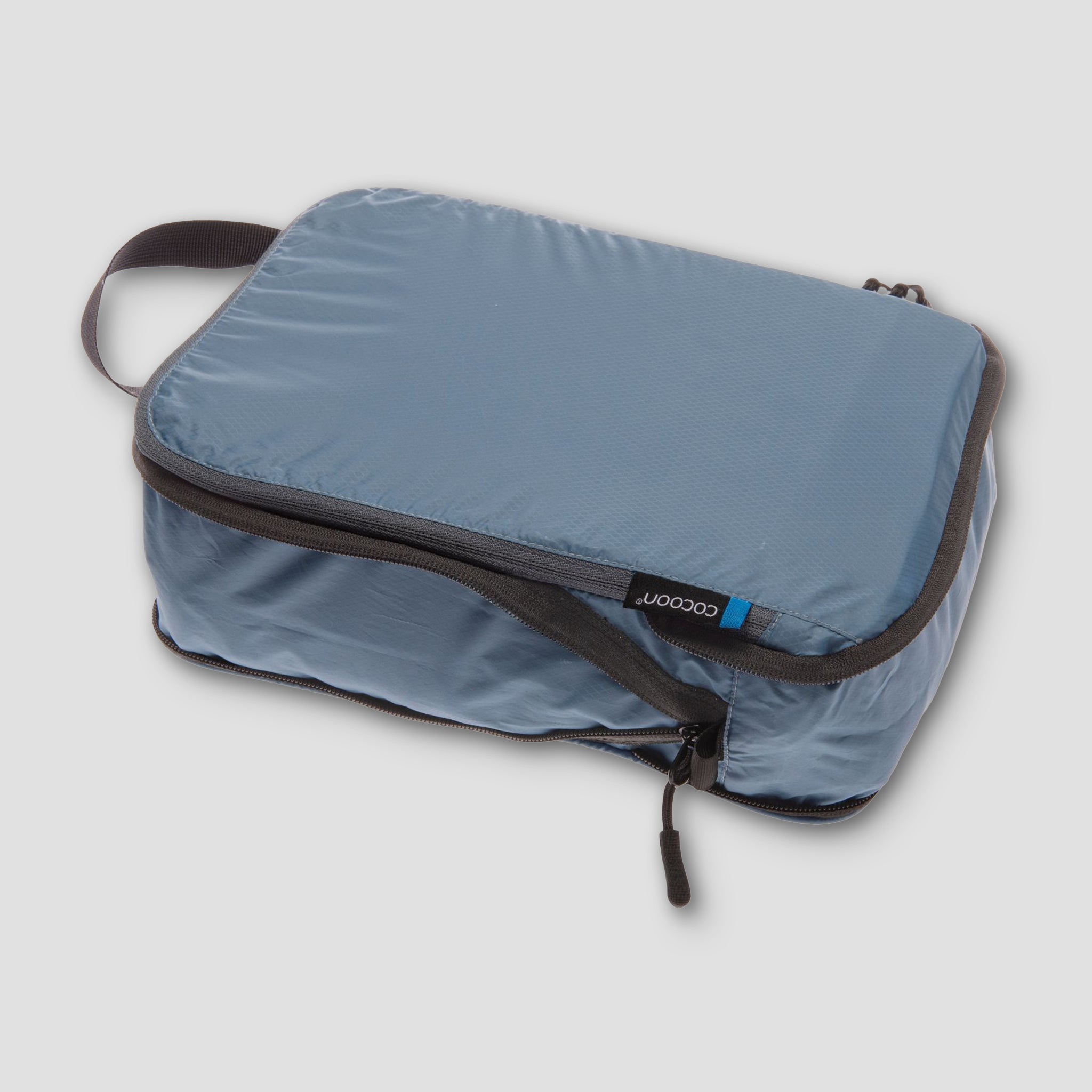 Blue packing cube with a zipper on a light gray background