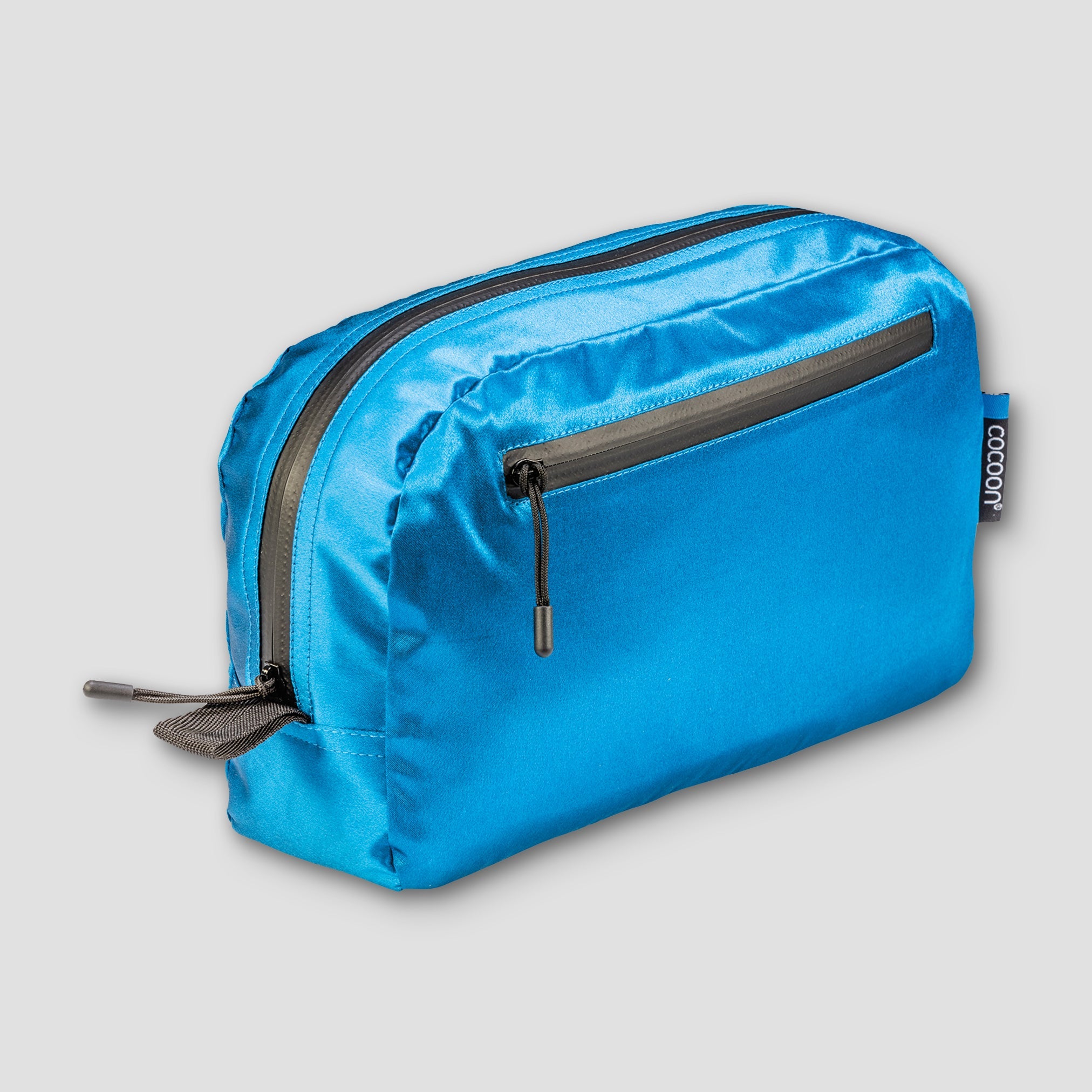 Blue toiletry bag with black zipper on a light gray background