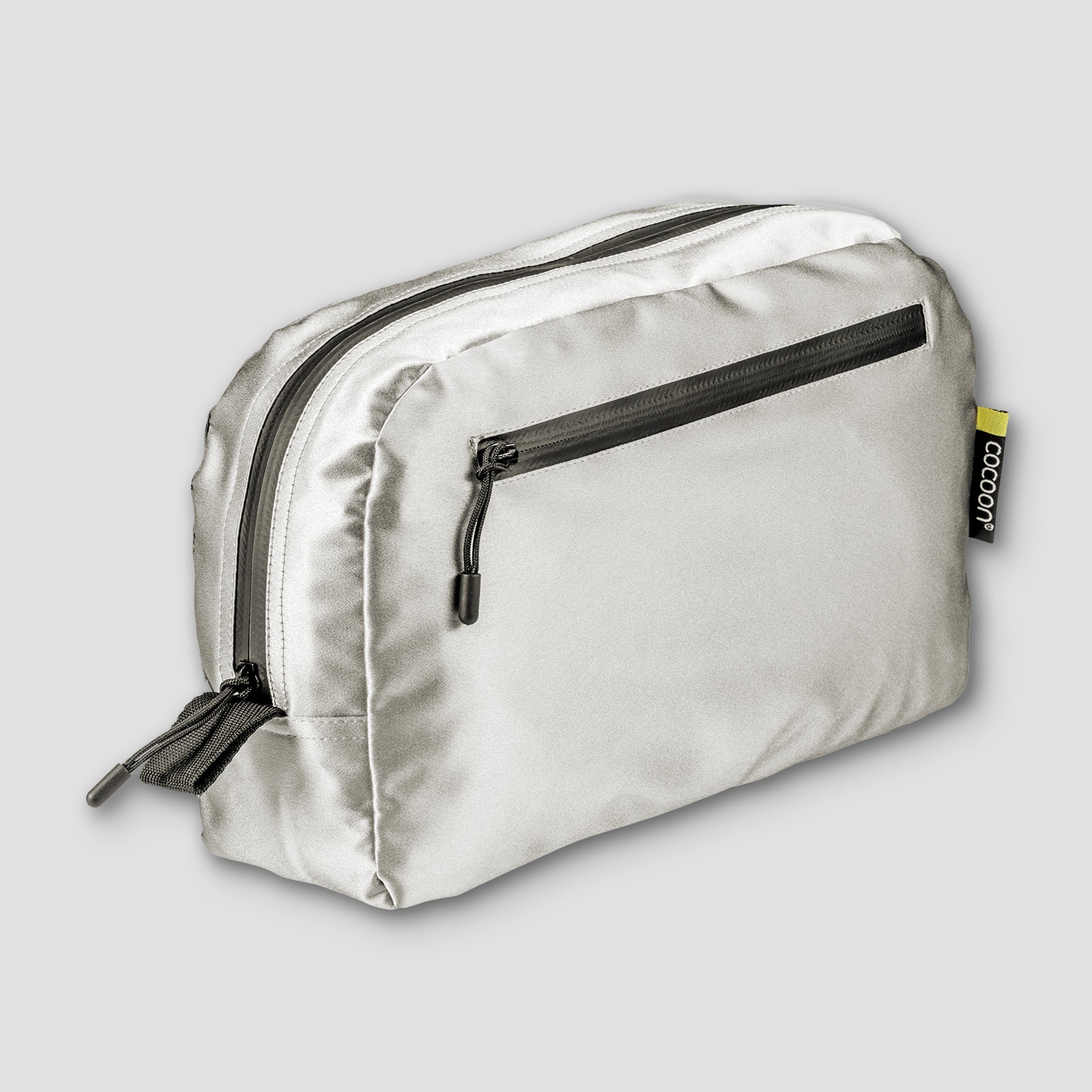 Silver toiletry bag with black zippers on a light gray background