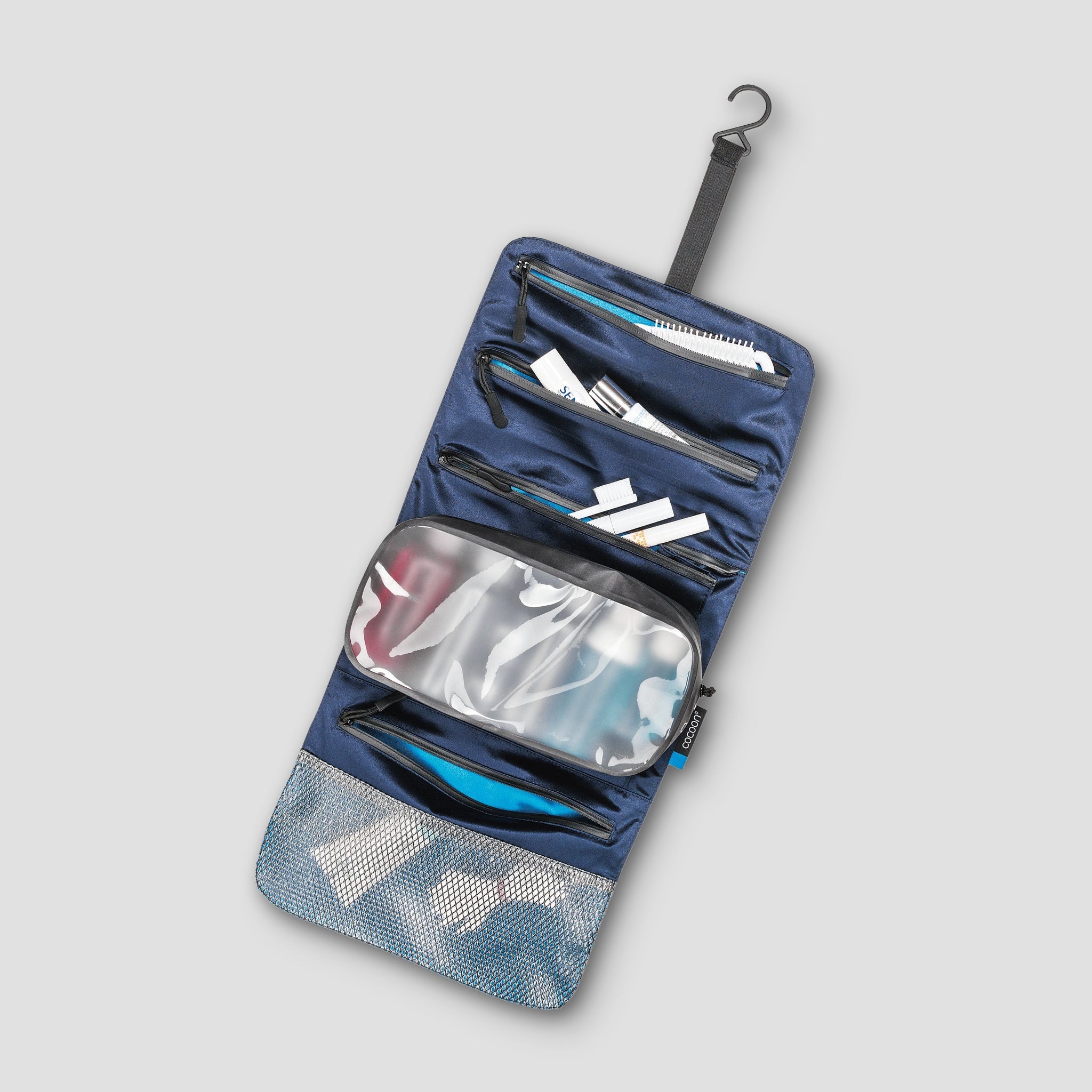 Blue travel organizer with zippers on a light gray background