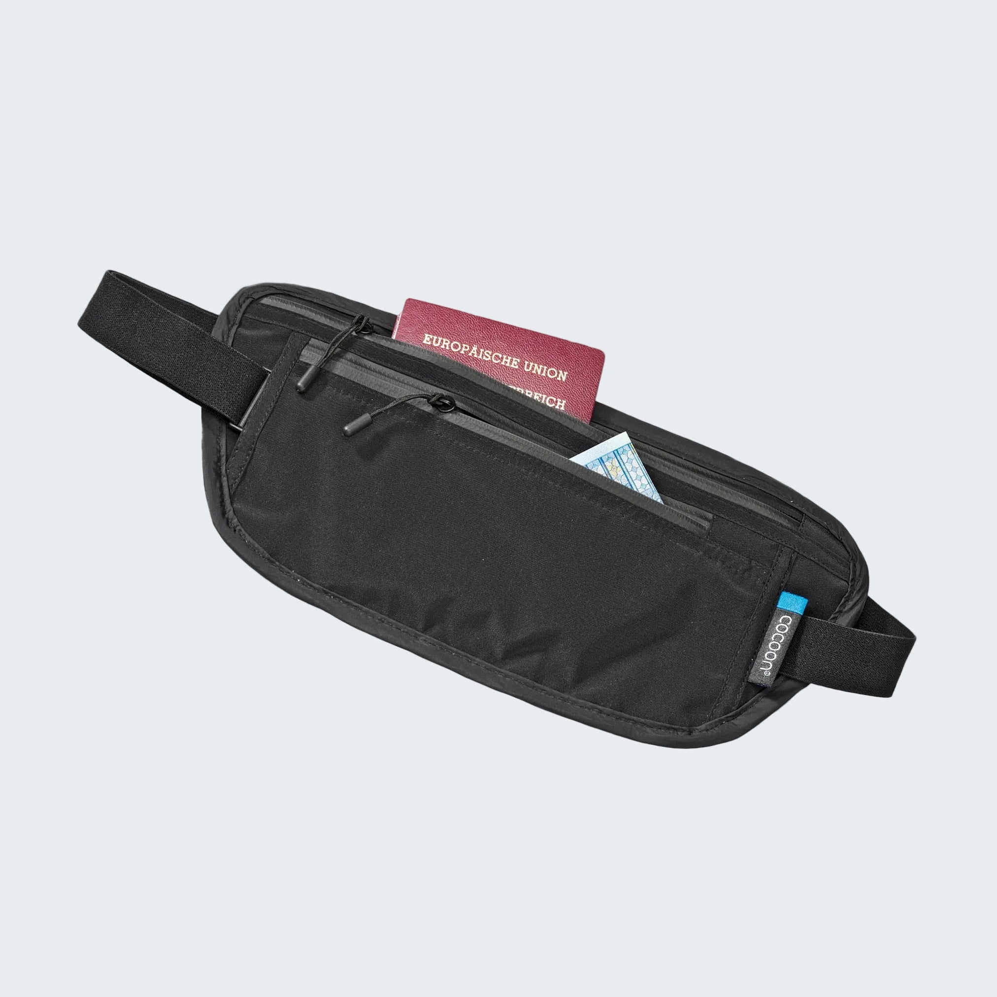 Black waist bag with travel documents on a light gray background