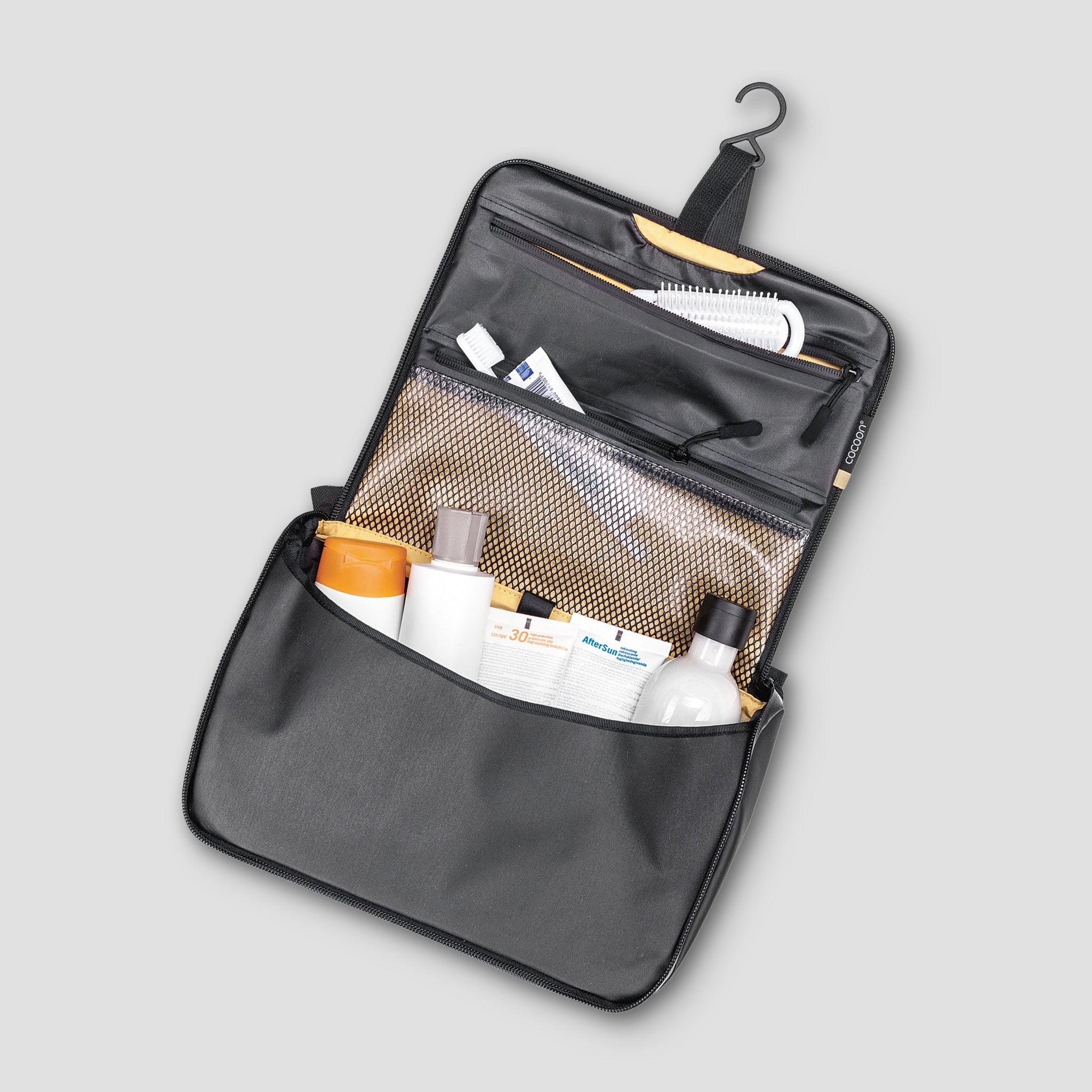 Open toiletry bag with personal care items on a light gray background